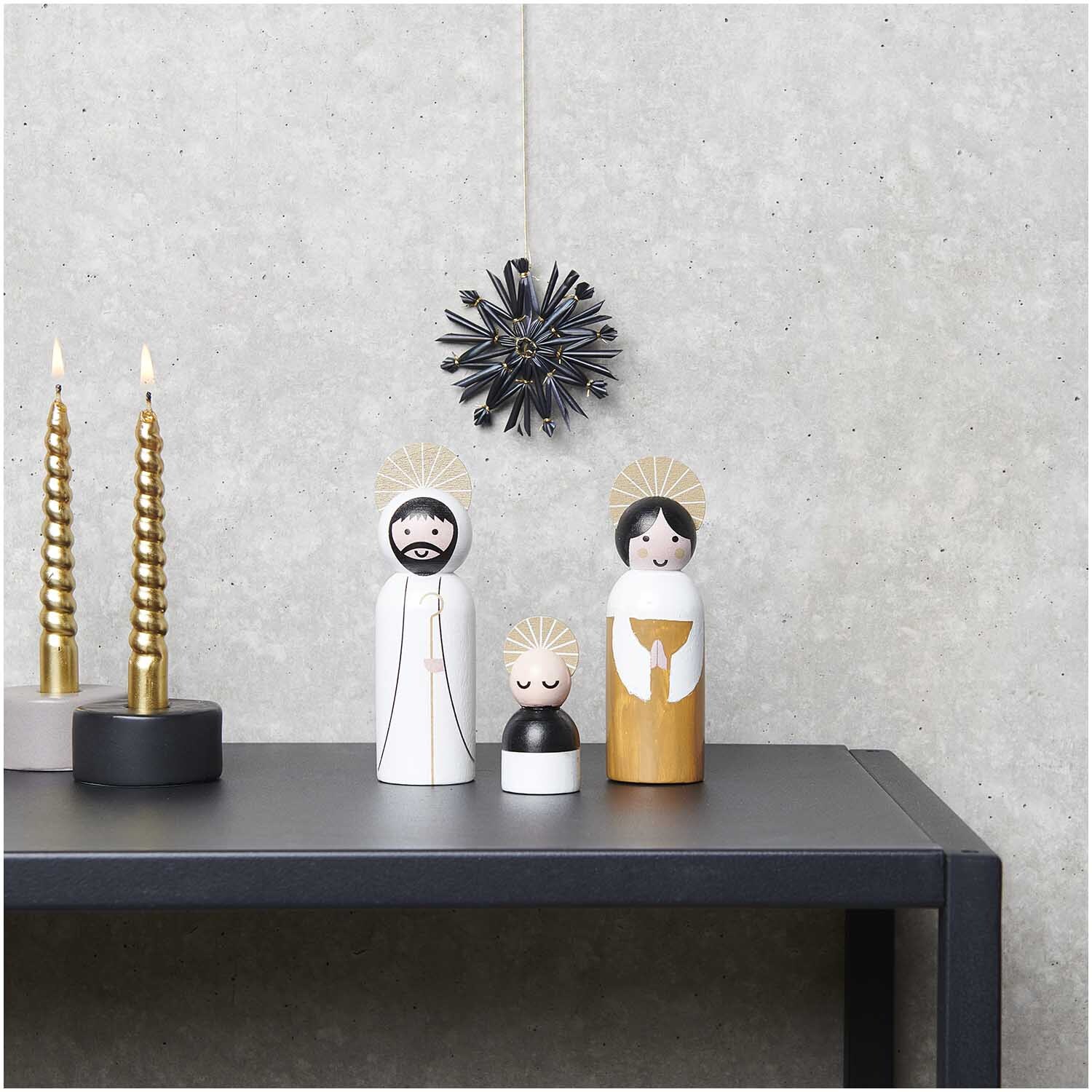 Voll-Holz-Krippen-Figuren natur, 3-teilig, auf einem Tisch mit dekorativen Kerzen und Wandornament.