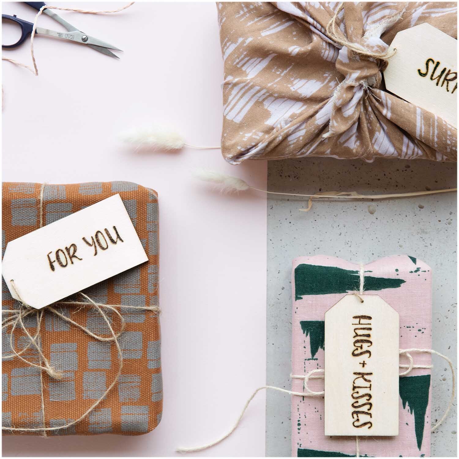 Holzdekoanhänger-Set Schild: Vier Geschenke mit dekorativen Anhängern, beige Stoffe, von Rico Design.