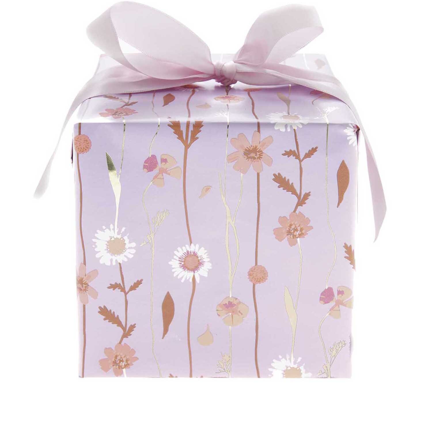Paper Poetry Geschenkpapier mit Blumenmuster in Flieder, verpackt als Geschenk mit rosa Schleife. Ideal für besondere Anlässe.