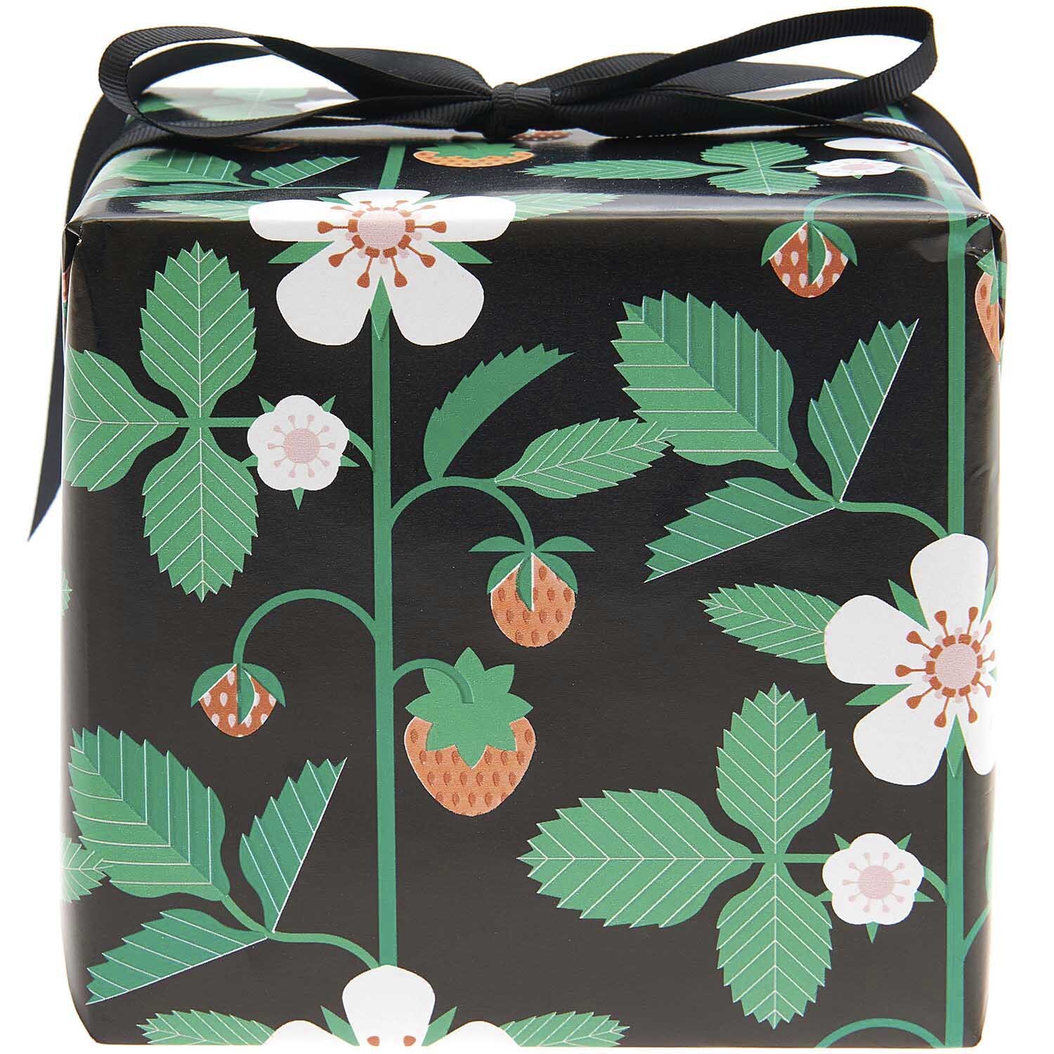 Geschenkpapier mit Erdbeermuster auf schwarzem Hintergrund, verpackt als Geschenk, von Rico Design.