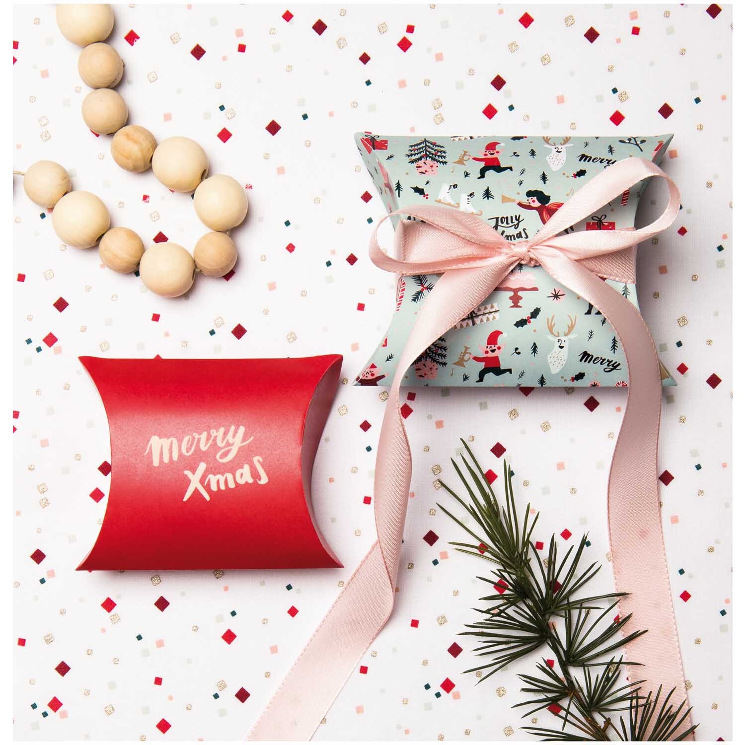 Paper Poetry Geschenkschachteln Jolly Christmas Classic von Rico Design, dekoriert mit rosa Schleife und weihnachtlichen Motiven auf festlichem Hintergrund.
