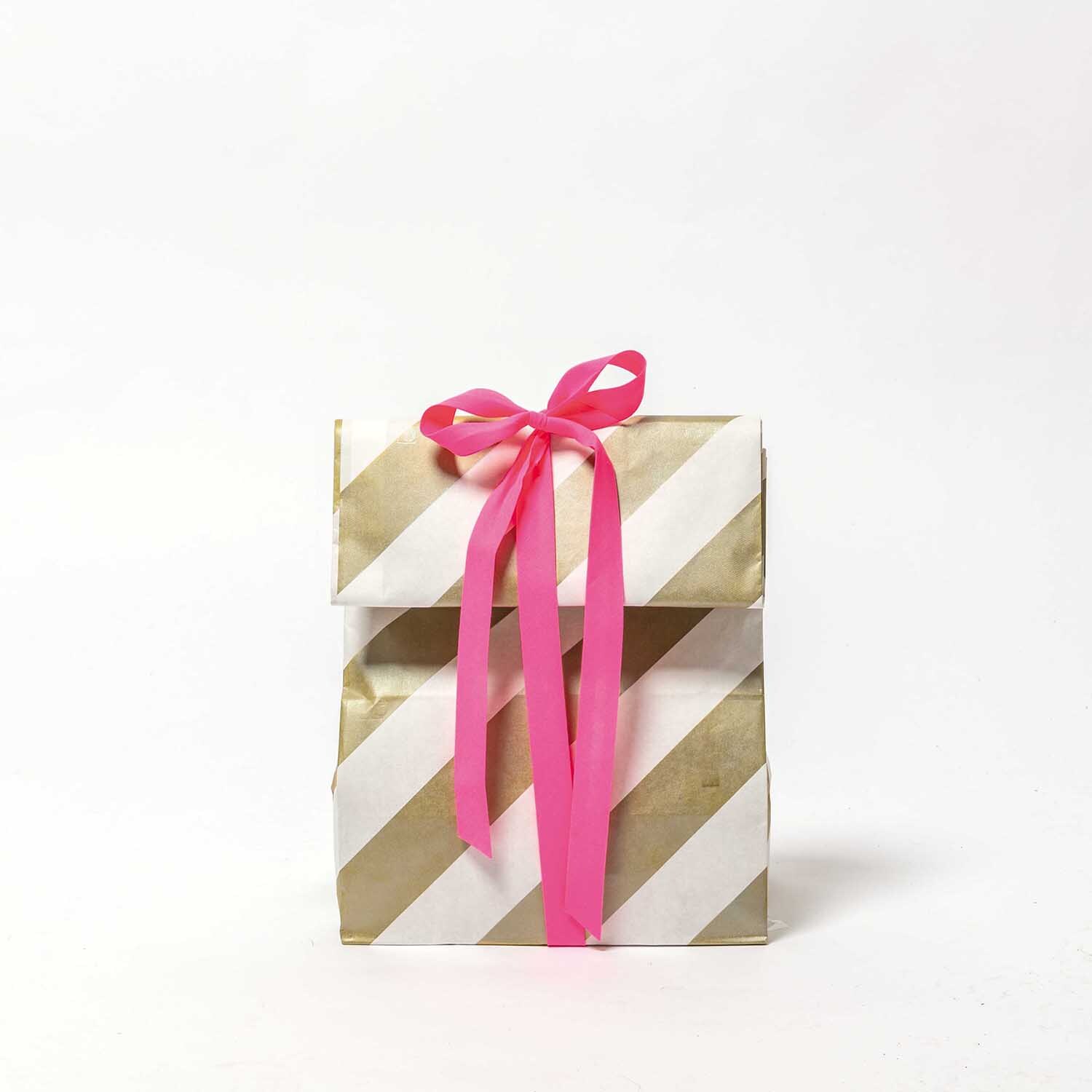 Paper Poetry Maxi-Blockbodenbeutel M Streifen, dekorativer Beutel in Weiß-Braun-Gold mit pinker Schleife, ideal für Geschenke.