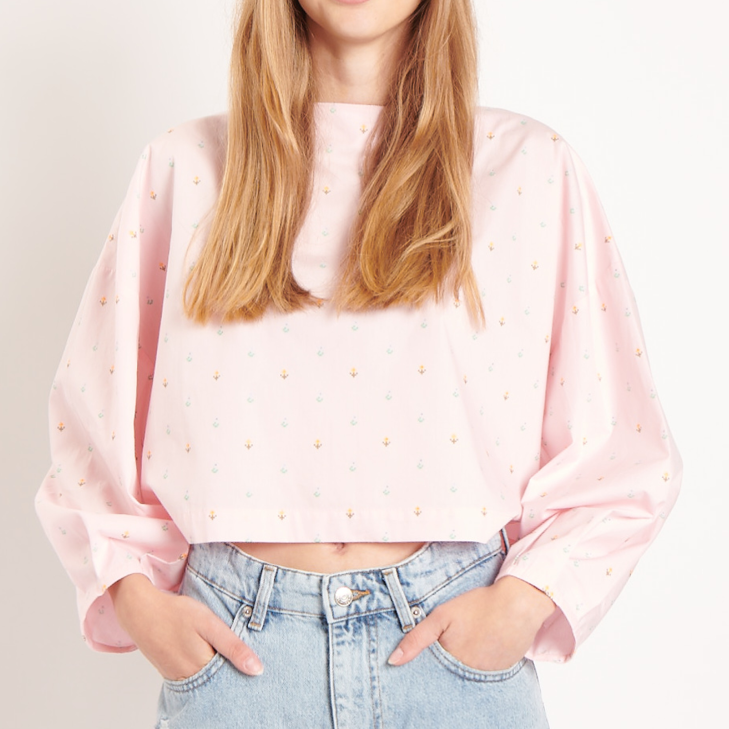 Nähanleitung Bluse mit Ballonärmeln: Frau trägt rosa Bluse mit weiten Ärmeln und Jeans.