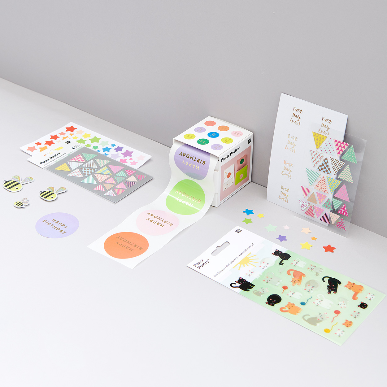 Bunte Sticker in unterschiedlichen Formen und Farben in Verpackung. Fotosetting graue Ecke.r