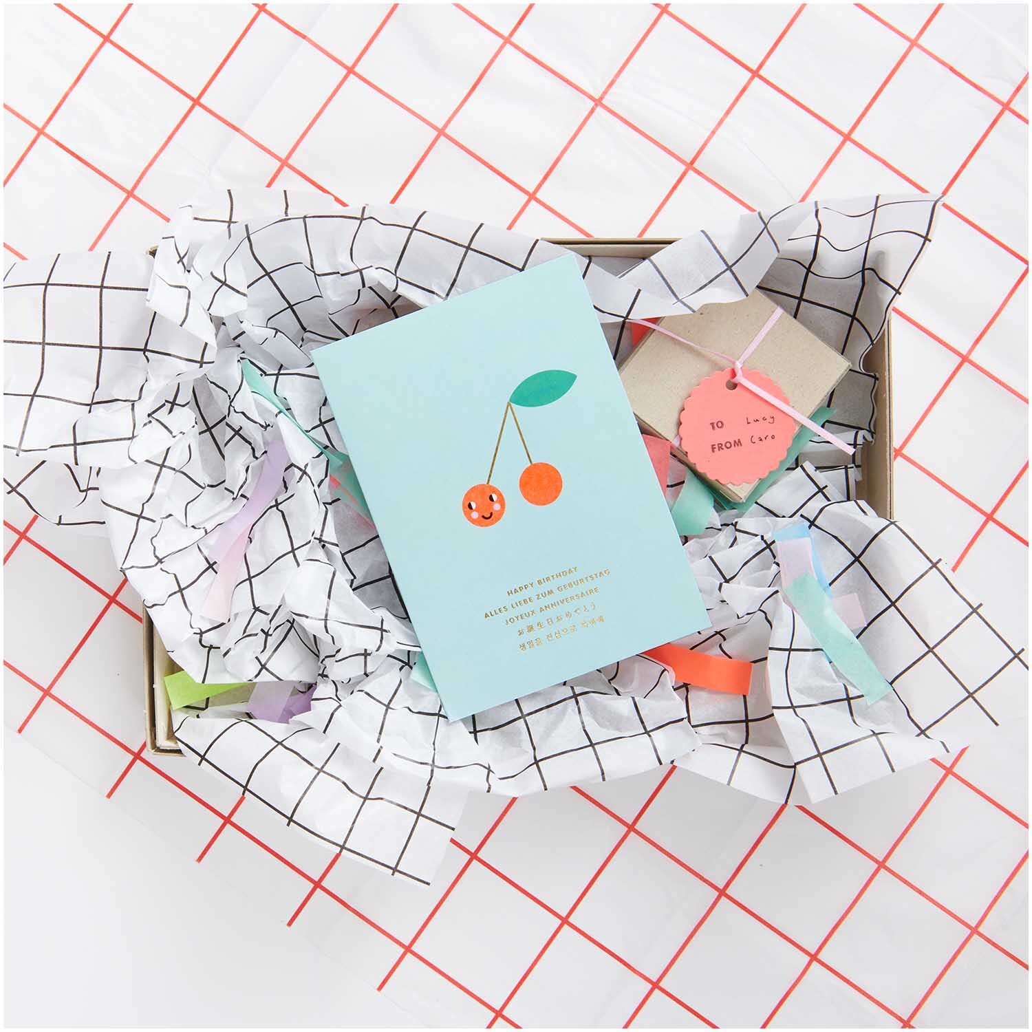Paper Poetry Seidenpapier in rot/weißem Rastermuster, dekoriert mit Geschenken und einer Karte in einer Box. Ideal für kreative Verpackungen.