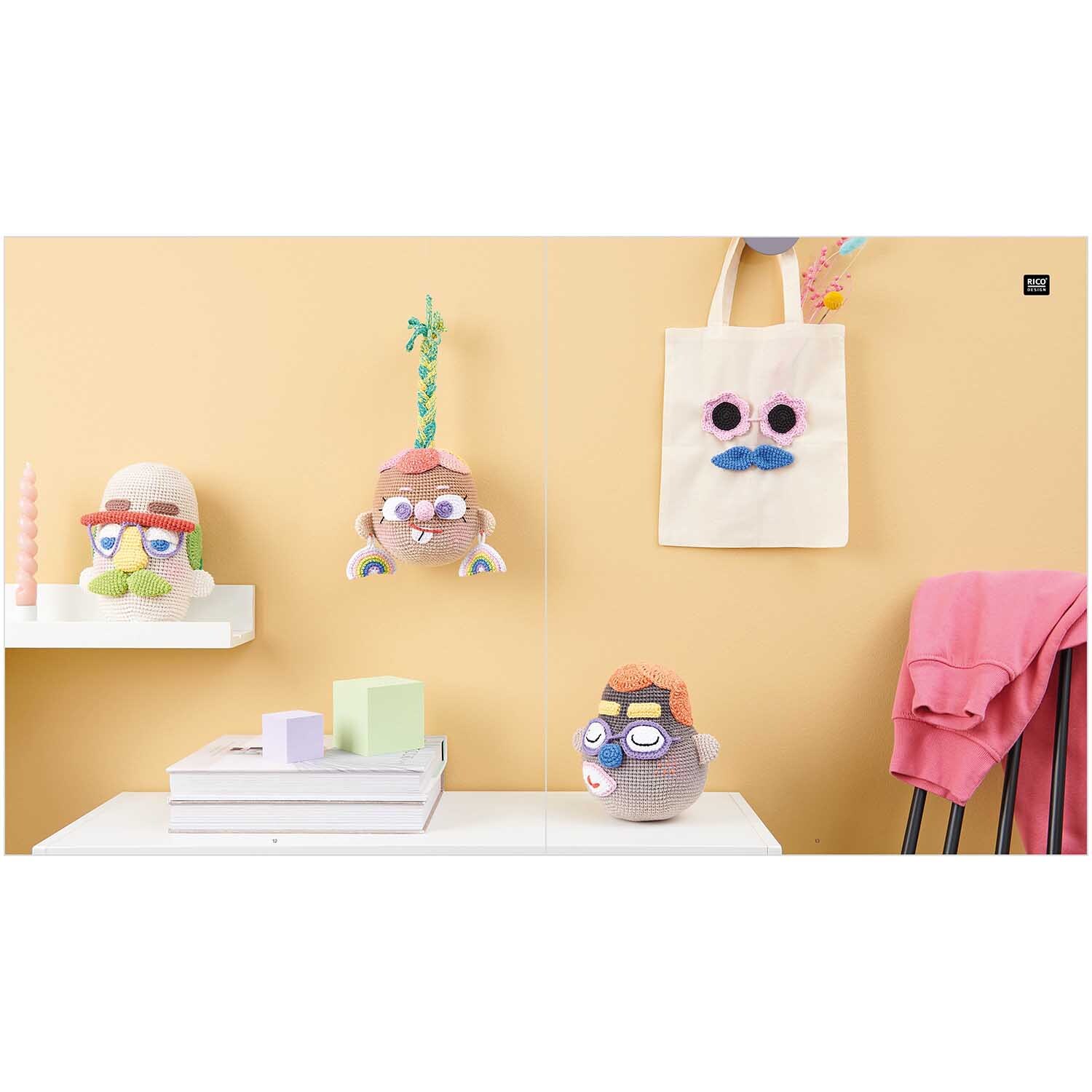 Ricorumi Crochet Your Face: Bunte, gehäkelte Gesichter und Accessoires an einer gelben Wand, mit Taschen und Dekorationen.