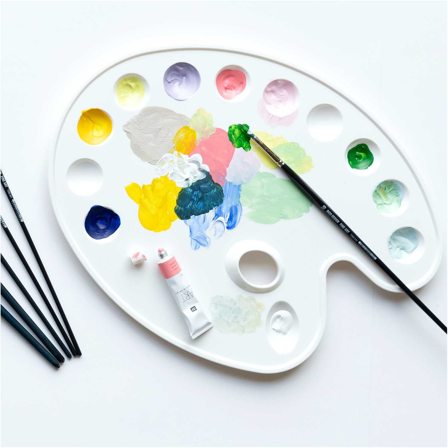 Kunststoffpalette mit 12er-Einteilung 25x35cm von Rico Design, weiß, mit bunten Farbfeldern und Pinseln.