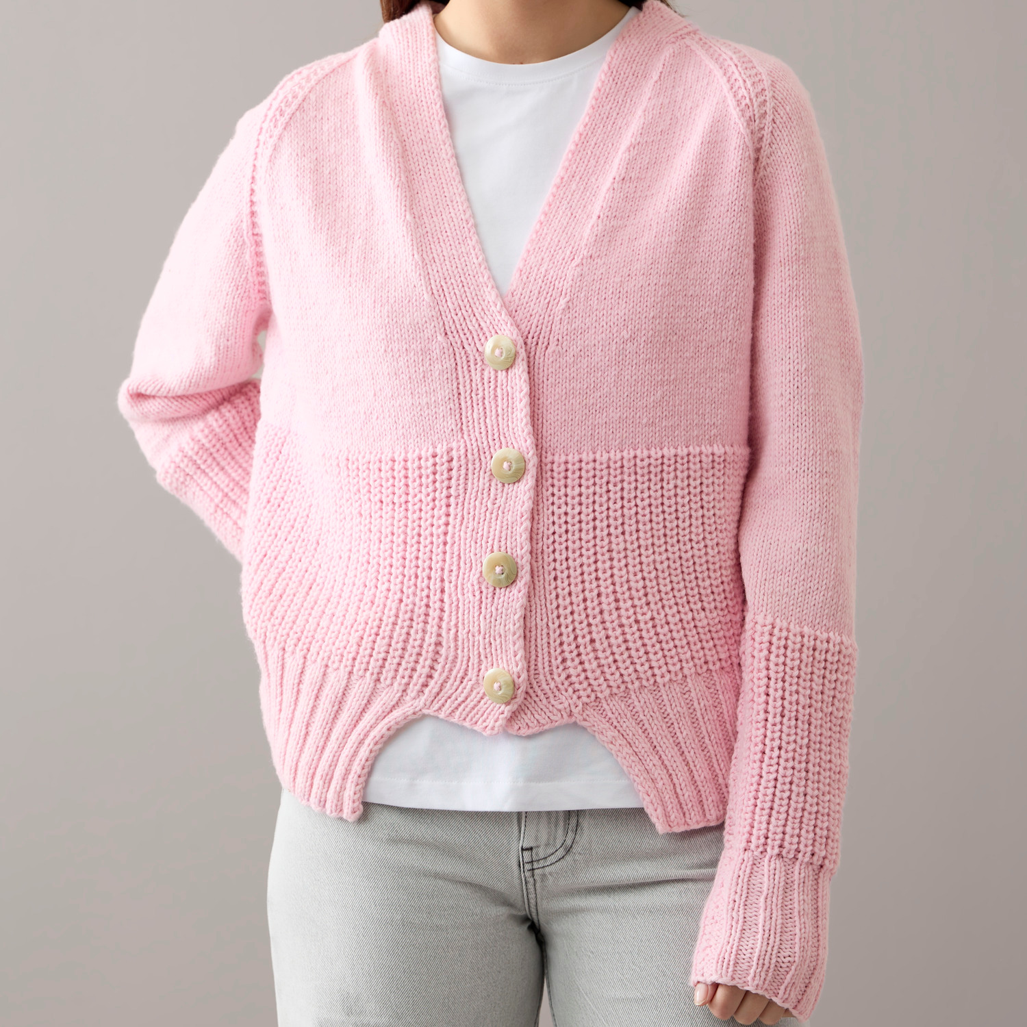 Special "Vegan Cashmere" Strickjacke in zartem Rosa von Rico Design, getragen von einer Person.