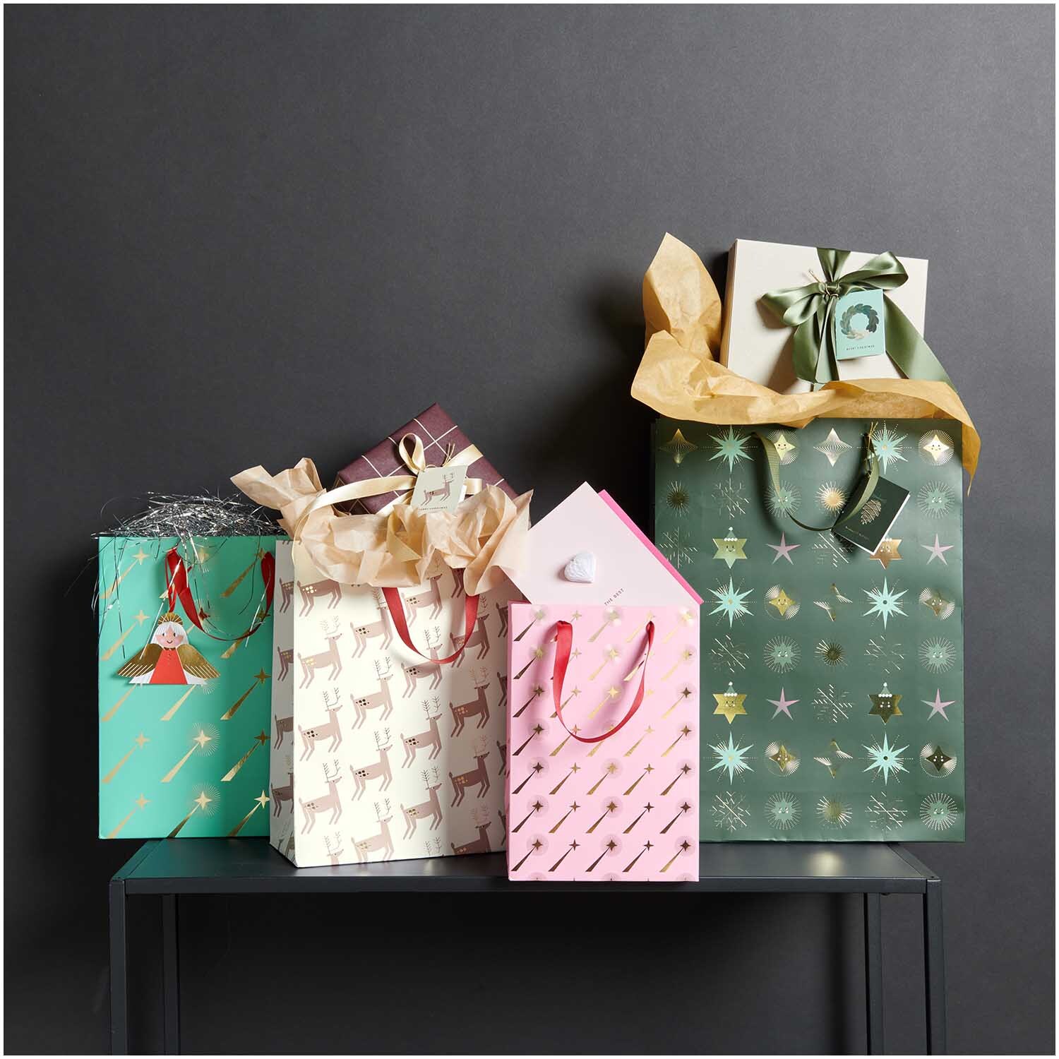 Paper Poetry Geschenktüte Rentiere 26x32x12cm: Bunte Geschenktüten mit Rentier- und Sternmotiven, ideal für festliche Anlässe.