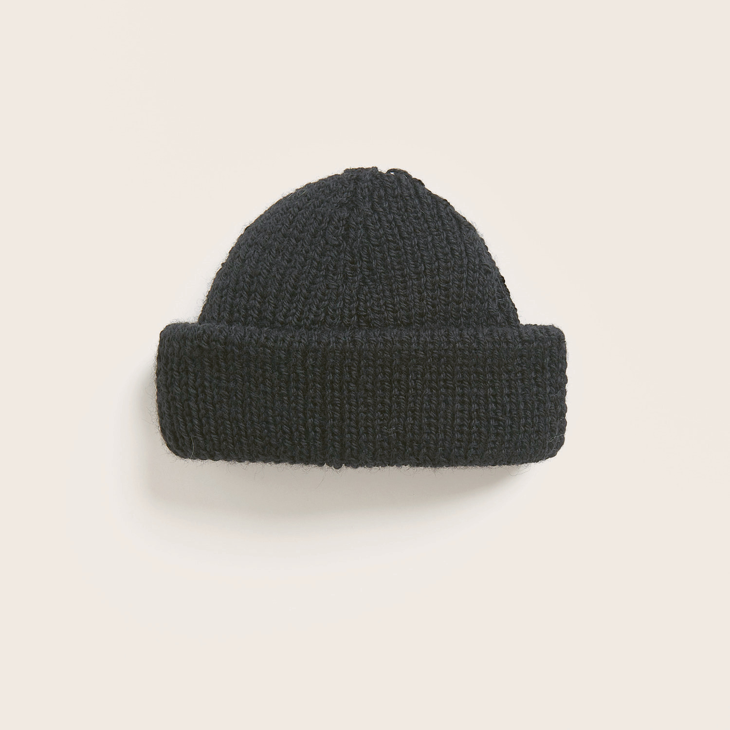 Strickset Mütze Modell 07 aus Trachtenbuch I mog di, schwarze gestrickte Mütze von Rico Design, präsentiert auf hellem Hintergrund.