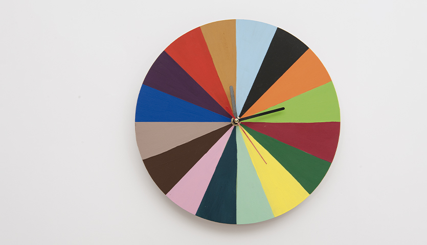 Bastelanleitung individuelle Uhren: Bunte, selbstgestaltete Uhr mit farbenfrohen Segmenten auf weißem Hintergrund.