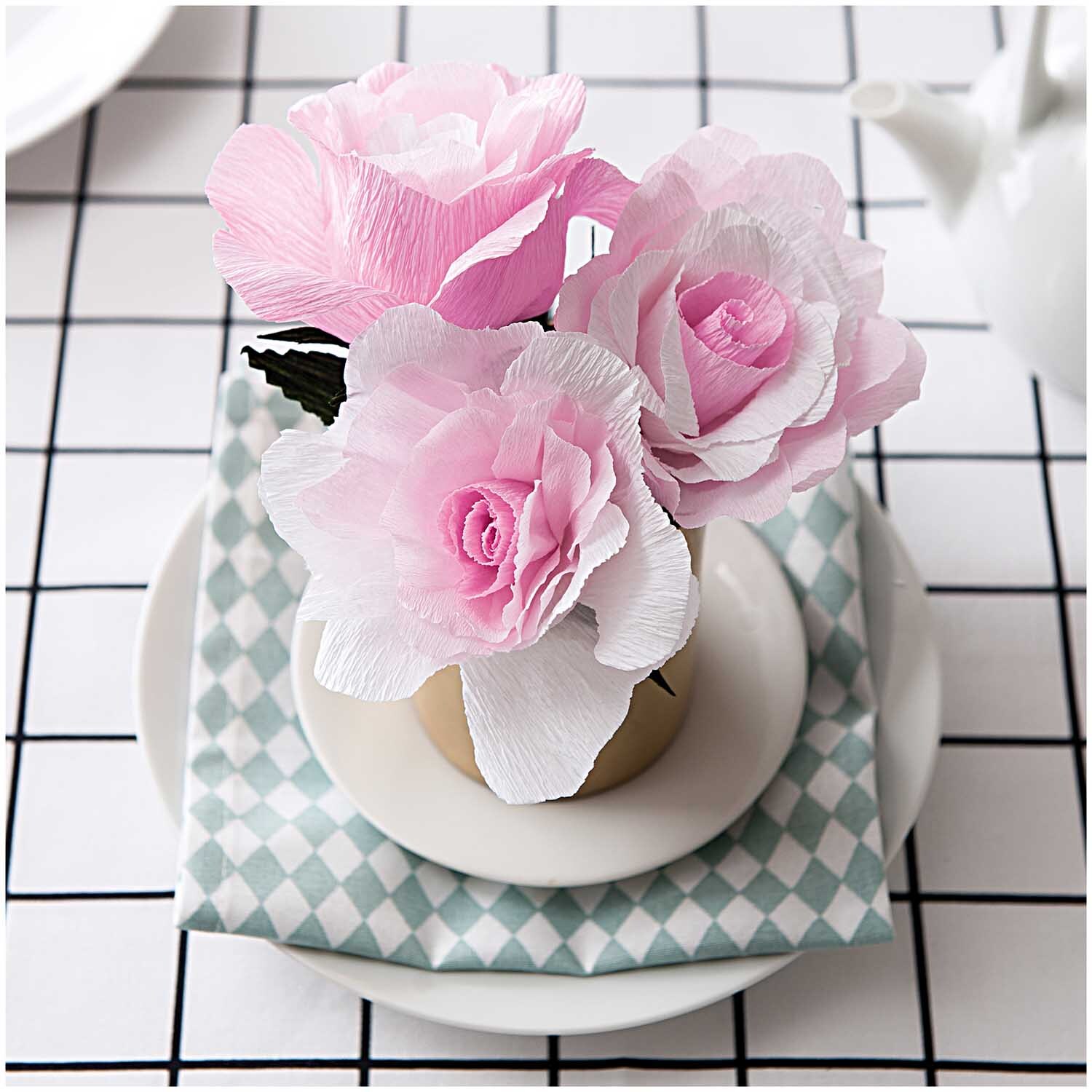 Stoff Karo weiß-schwarz 140cm beschichtet: Rosa Papierblumen in Vase auf kariertem Tischtuch, stilvoll arrangiert.