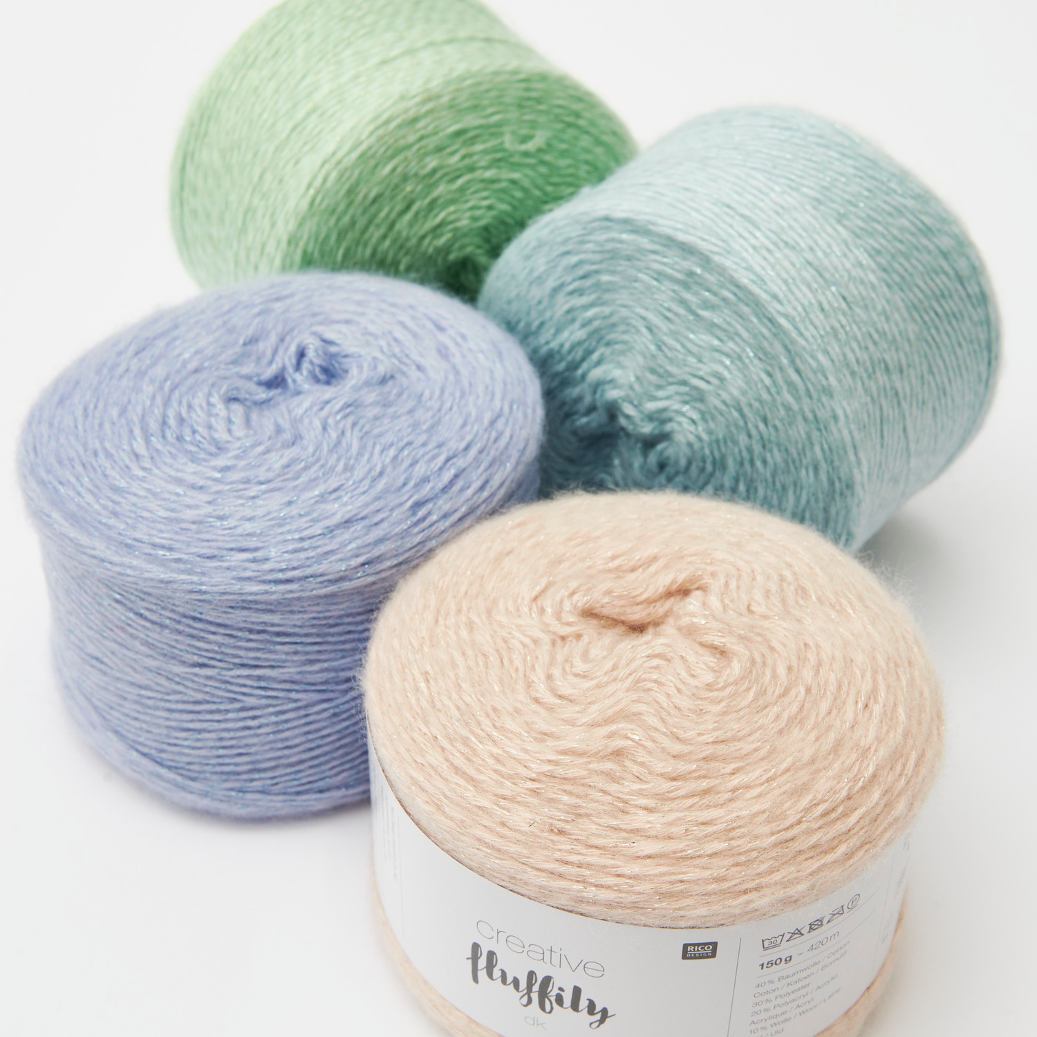Creative Fluffily dk Sortiment III zeigt vier Wollknäuel in Pastellfarben von Rico Design.