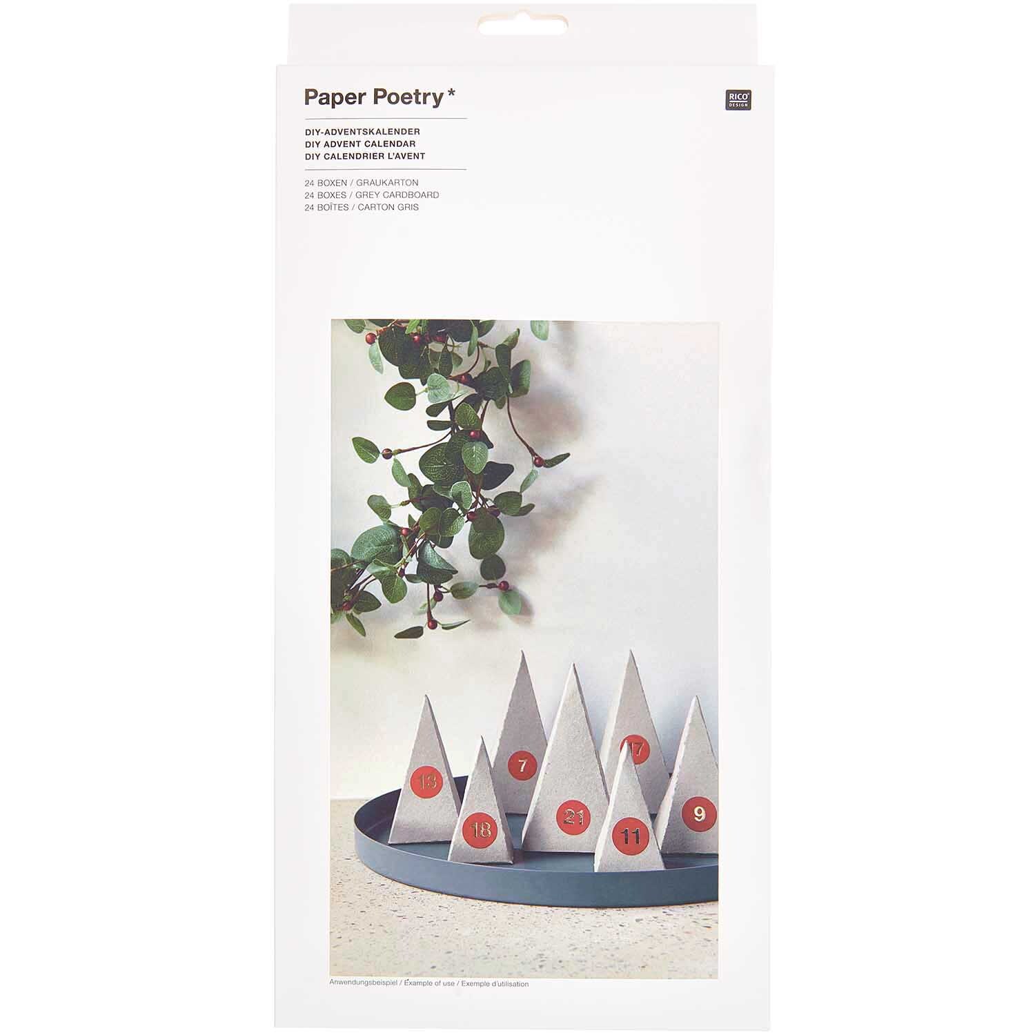 Paper Poetry Adventskalender Bäume 24 Stück aus Graukarton, dekoriert mit roten Zahlen, auf einem Tablett vor einer Pflanze.