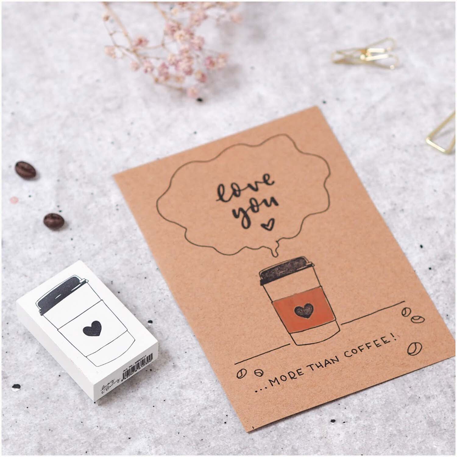 Stempel Kaffeebecher weiß 35x55mm zeigt einen Kaffeebecher-Stempel neben einer Karte mit Herzmotiv.