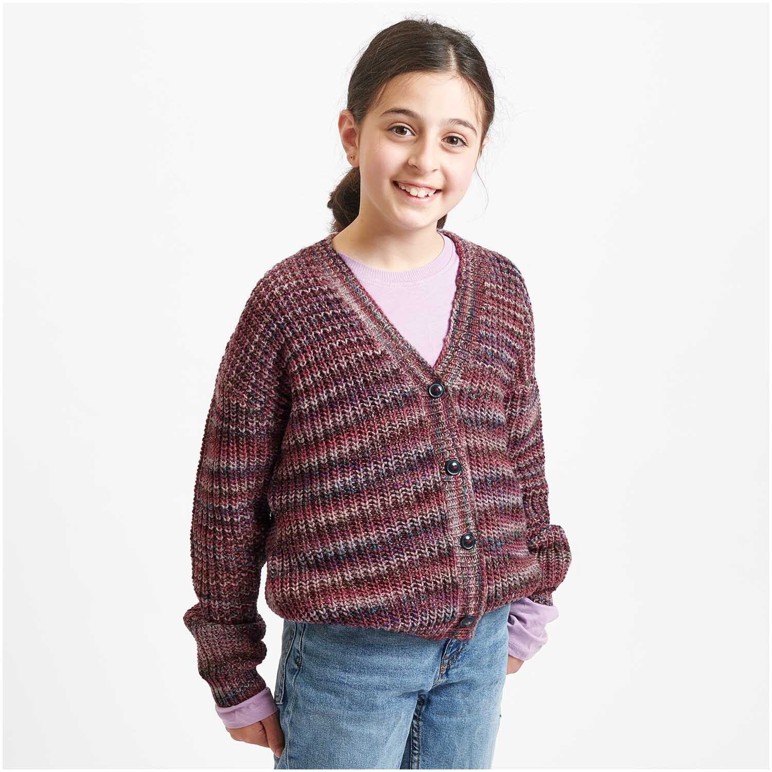Creative Colour Shift dk: Mädchen trägt gestrickte Jacke in Beerenfarben von Rico Design, lächelnd.