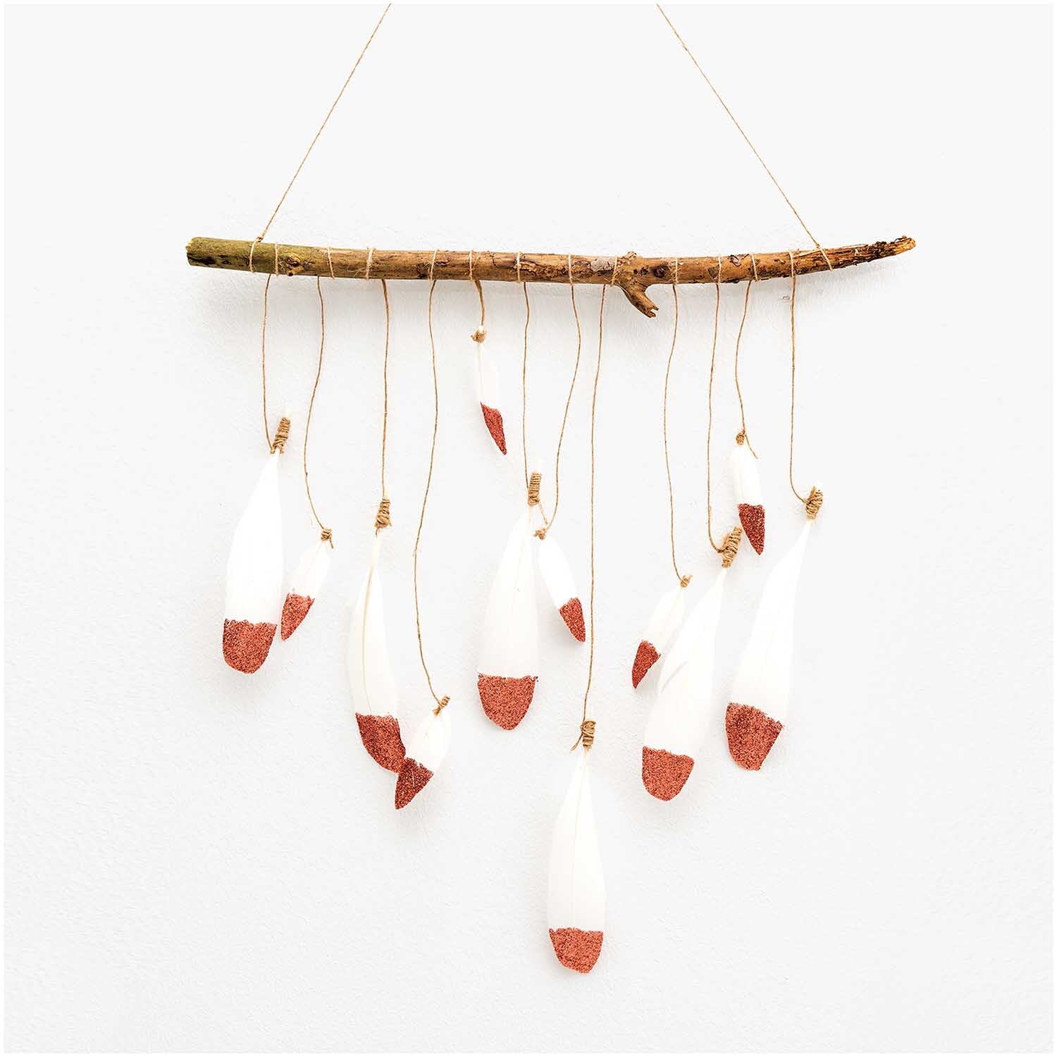 Federn ca. 8cm 6 Stück: Dekorative weiße Federn mit roségoldenen Spitzen, aufgehängt an einem Ast. Ideal für kreative Projekte von idee. Creativmarkt.