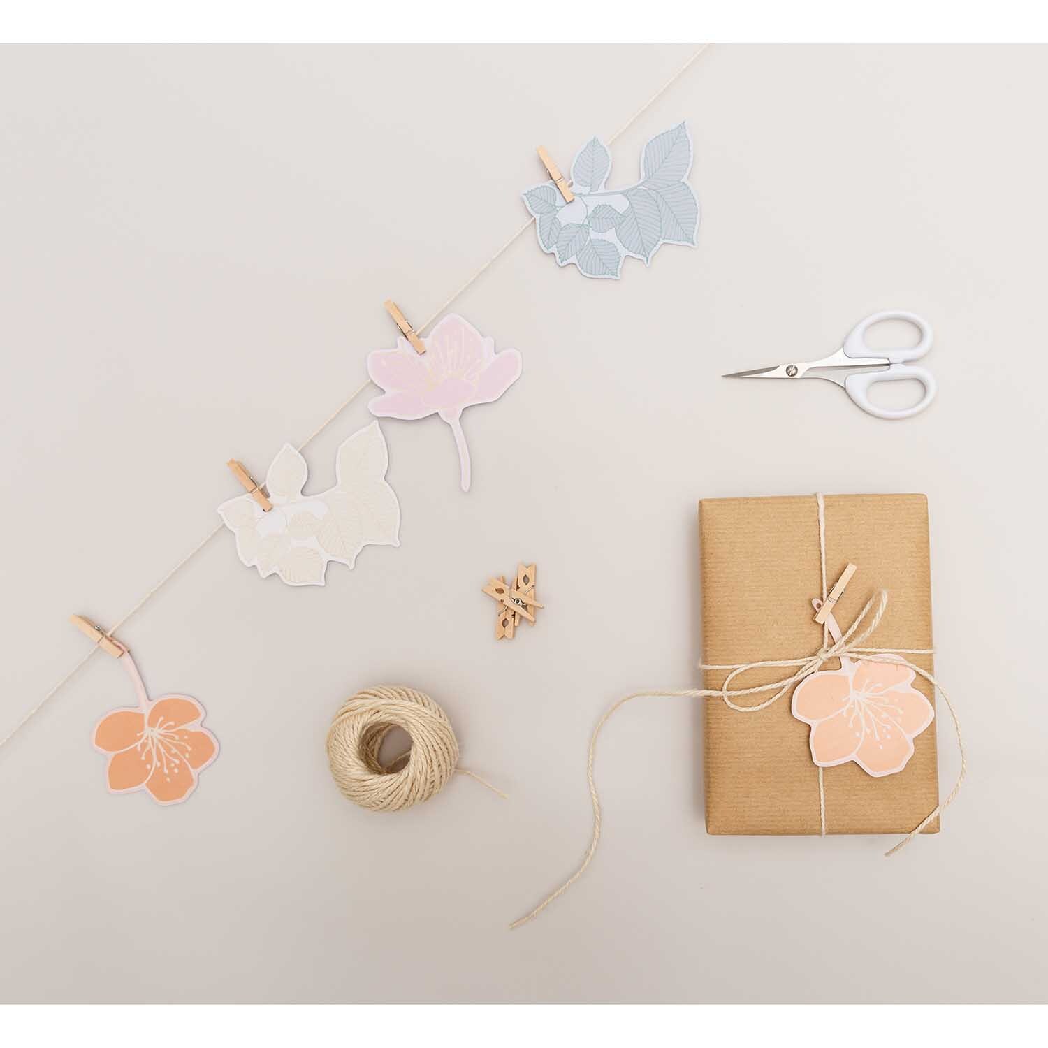 Paper Poetry Papieranhänger Blüten 8 Stück, dekorativ arrangiert mit Schere, Garn und Geschenk.