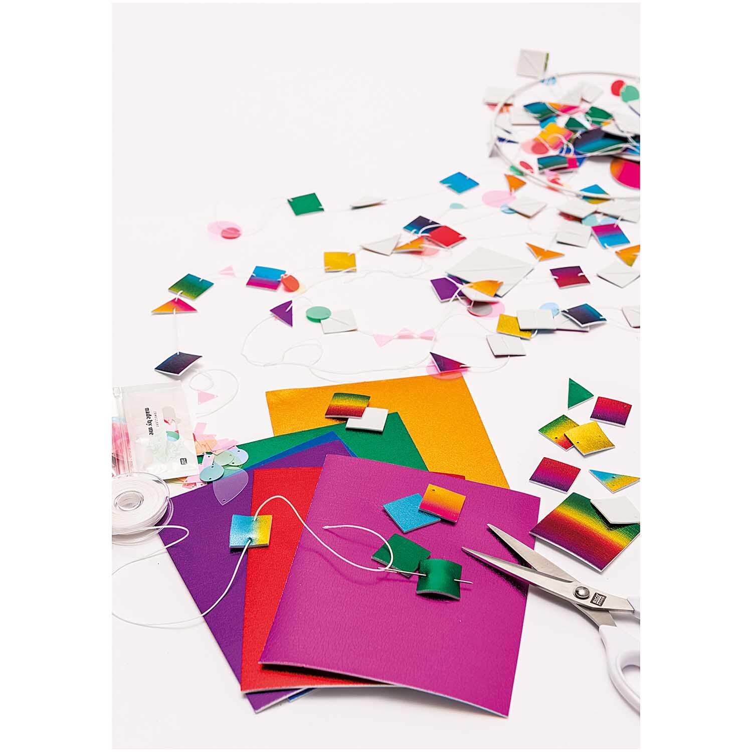 Moosgummimix 2mm 20x30cm 10 Farben: Bunte Bastelmaterialien und Schere auf weißem Hintergrund.