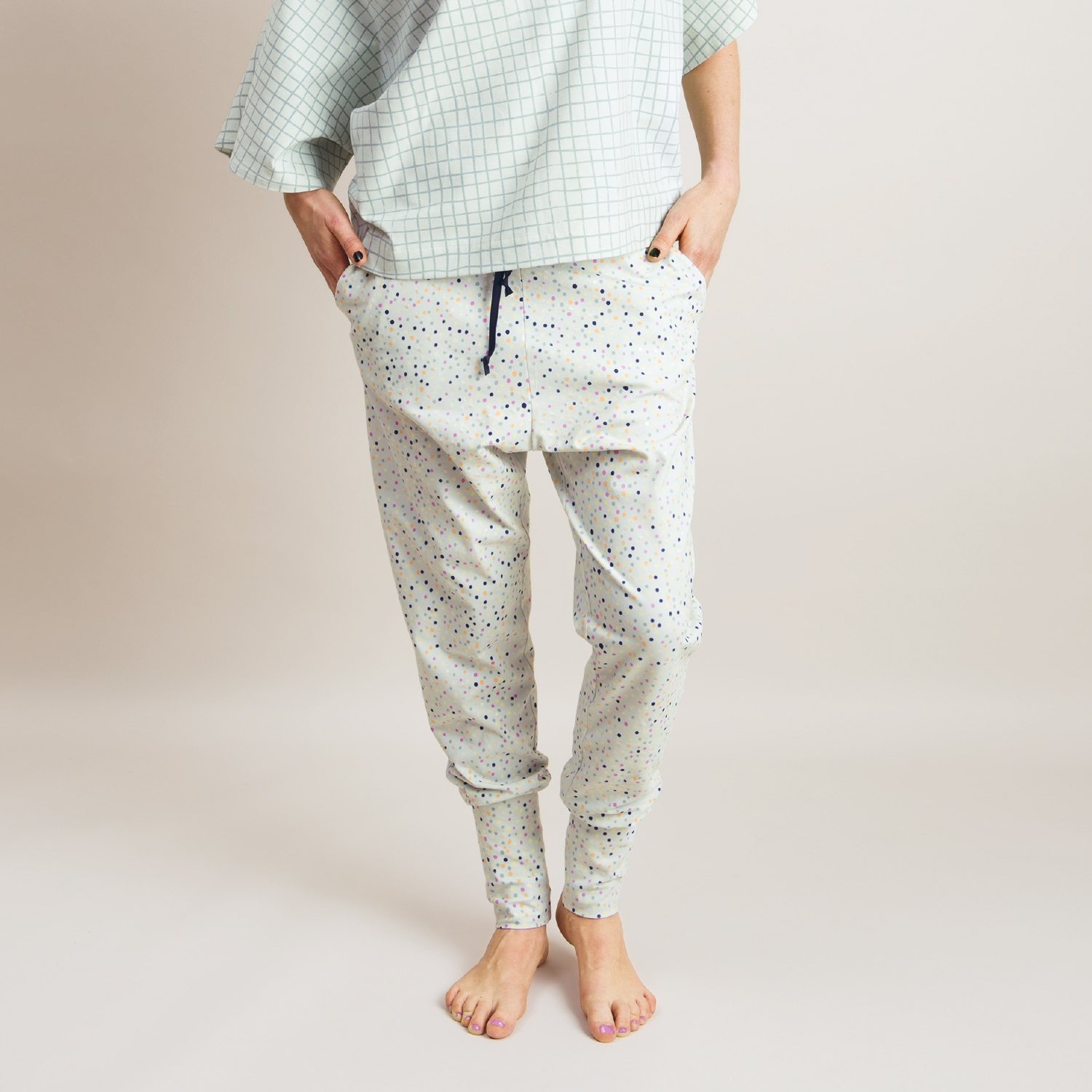 Nähanleitung Gemütliche Jerseyhose: Person trägt helle, gepunktete Jerseyhose mit Taschen, ideal für Freizeit und Komfort.