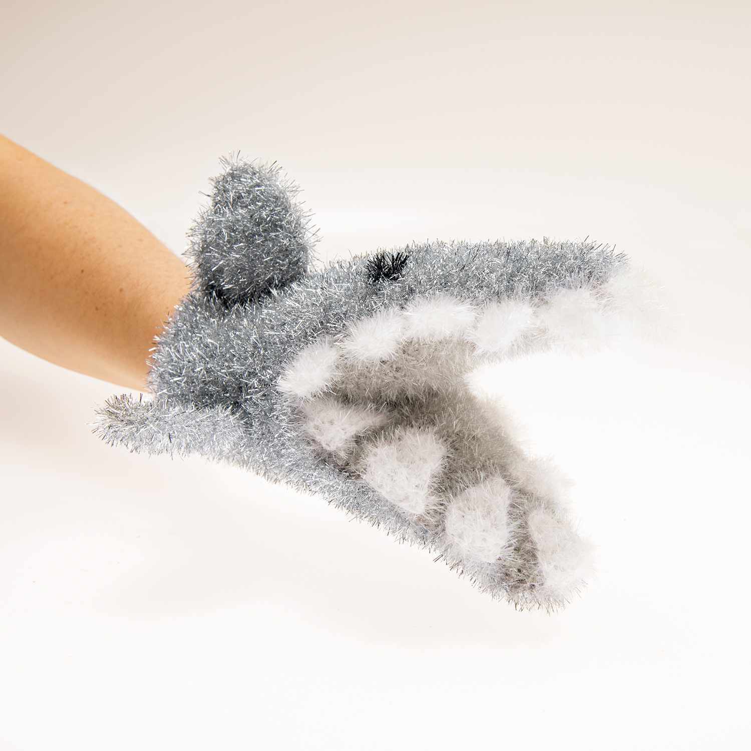 Häkelanleitung Waschhandschuh Hai: Ein grauer, flauschiger Waschhandschuh in Form eines Hais auf einer Hand.