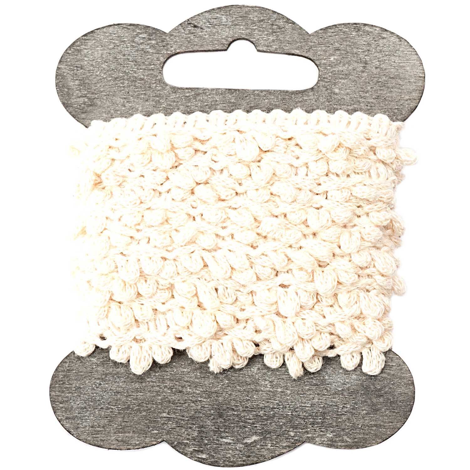 Häkelbordüre 1,5cm 3m: Cremefarbene Spitze auf Holzspule, ideal für kreative Nähprojekte.