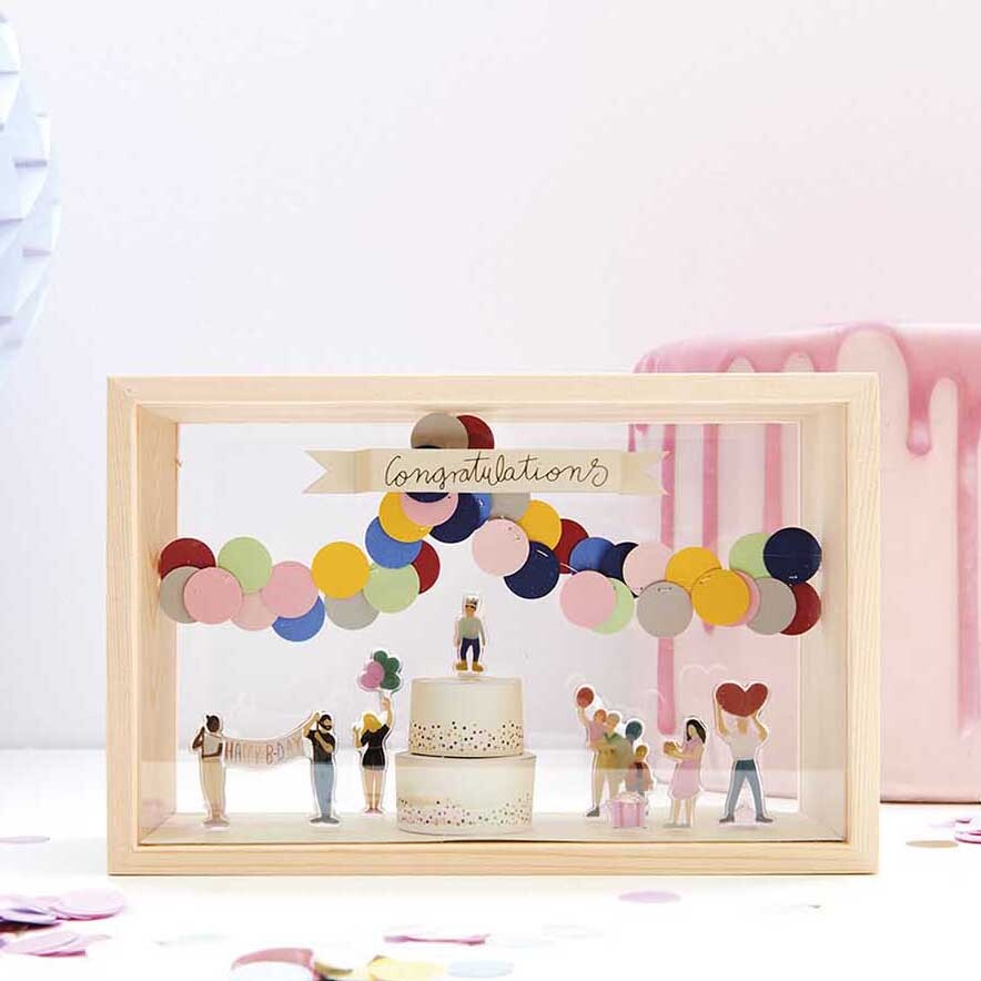Figurico Gelsticker Geburtstag: Bunte Dekoration mit Figuren und Torte in Holzrahmen.