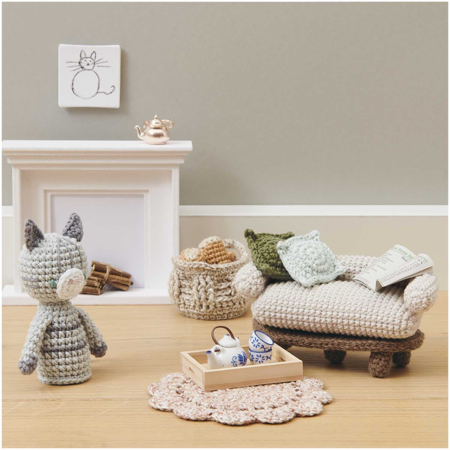 Ricorumi Set Wichtelwelt: Gemütliche Häkel-Szene mit Sofa, Katze, Kamin und Teeservice, ideal für kreative Handarbeitsprojekte.