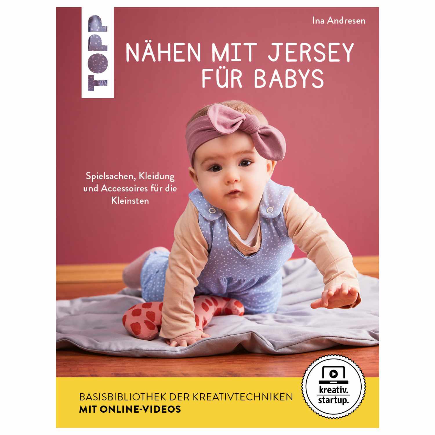 Nähen mit Jersey für Babys: Ein Baby in rosa Mütze und Kleidung auf grauer Decke, TOPP Verlag.