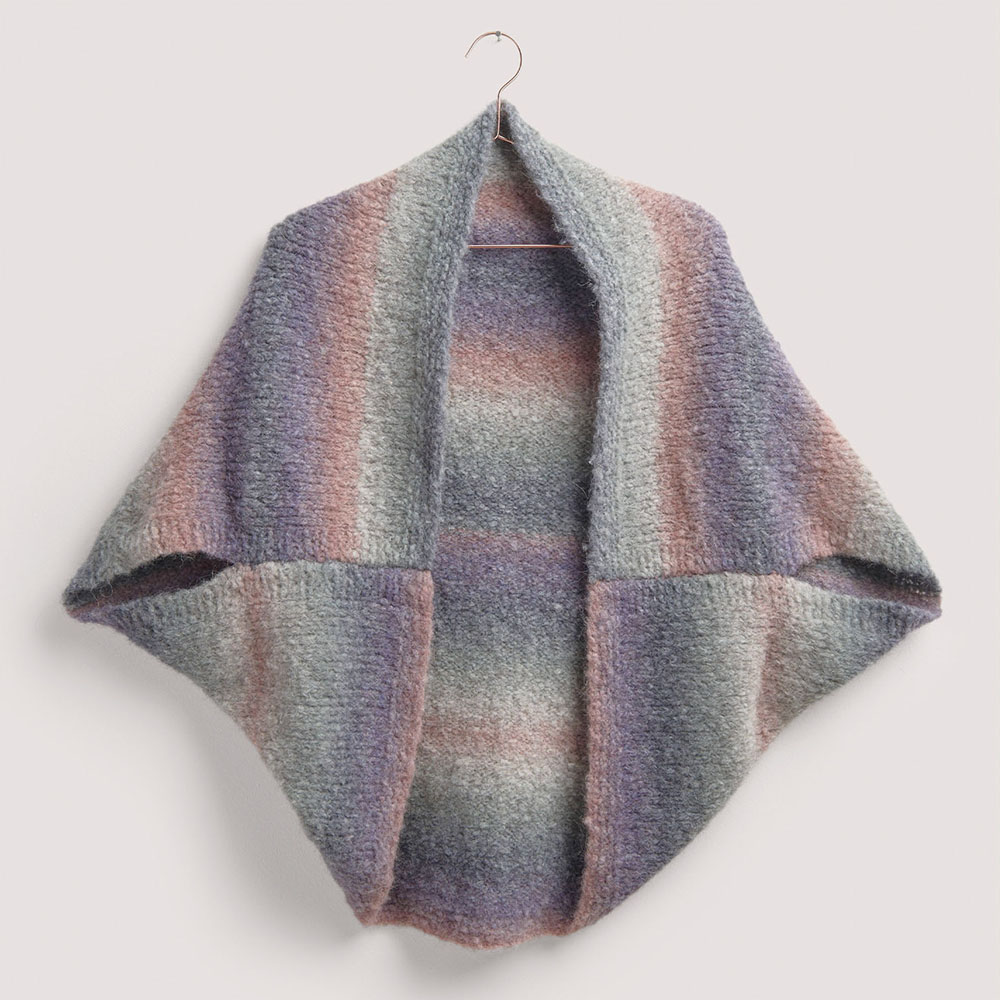 Poncho auf grauem Hintergrund – zum Strickset
