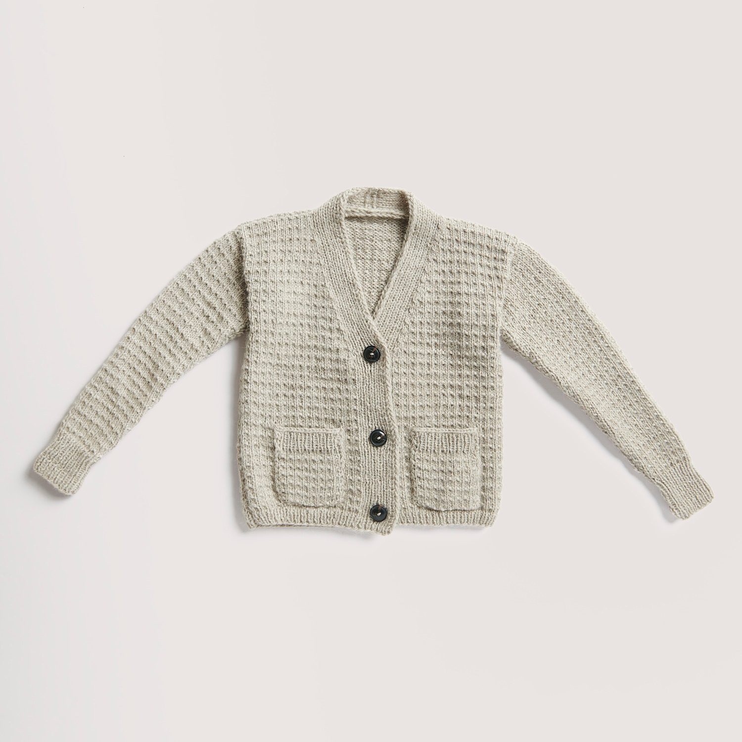 Strickset Cardigan Modell 13 aus Rico Kids 13: Beiger Cardigan mit Knöpfen und Taschen, gestrickt aus weicher Alpaka-Wolle von Rico Design.