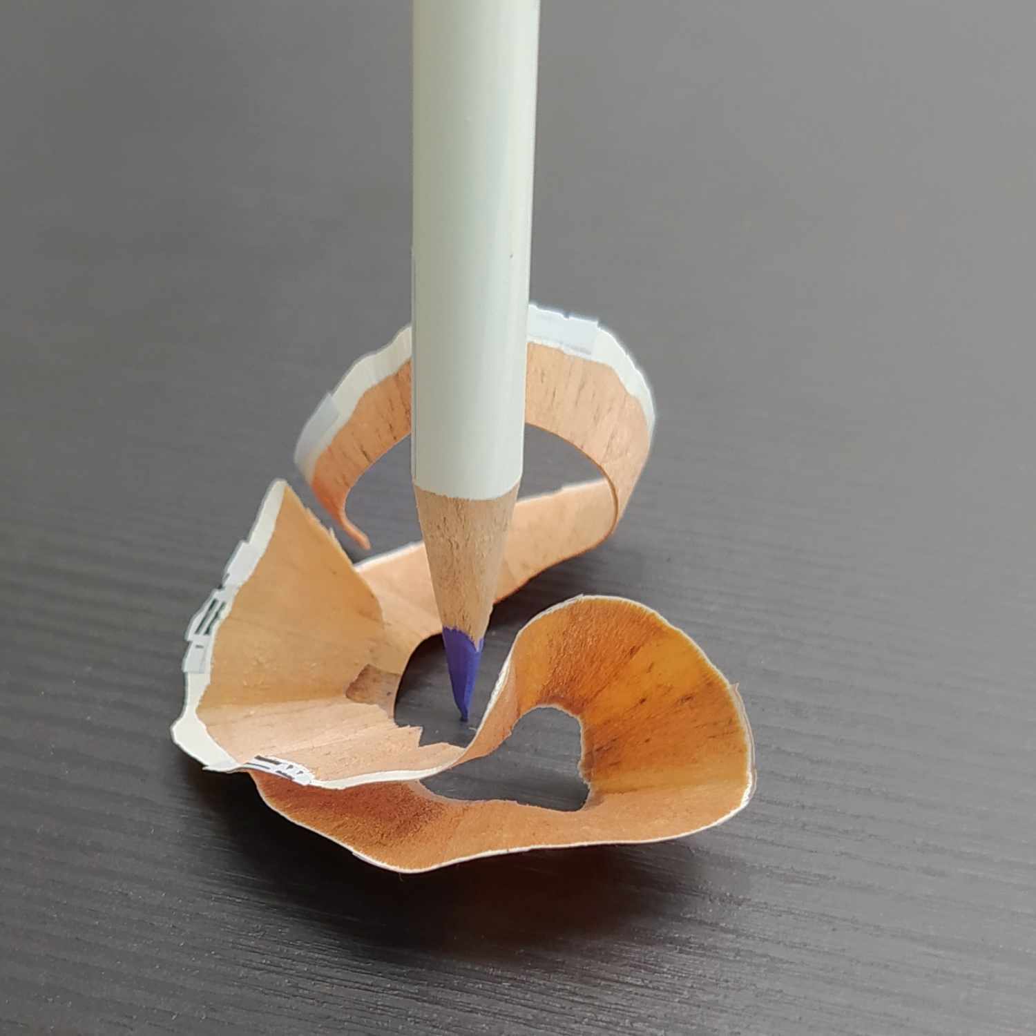 IROJITEN Farbstift von Tombow, weiß, spitzt Holz auf schwarzem Tisch, zeigt Präzision und Qualität.