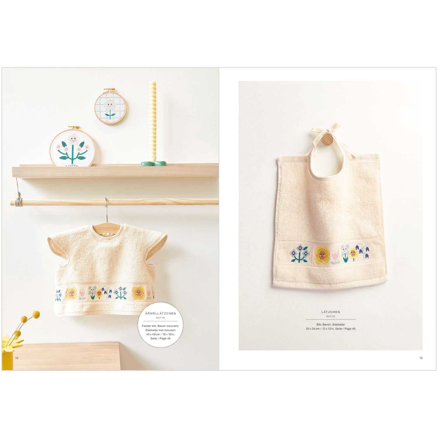Stickbuch Happy Baby Nr. 179: Handtuch und Lätzchen mit floralen Stickmustern, präsentiert auf Holzregal.