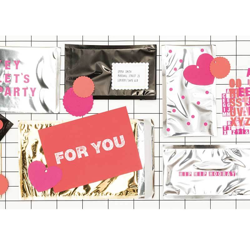 Versandtaschen Metallic C5 5 Stück von Rico Design in Rosa und Pink mit holographischem Effekt, dekoriert mit bunten Kreisen auf einem Gitterhintergrund.