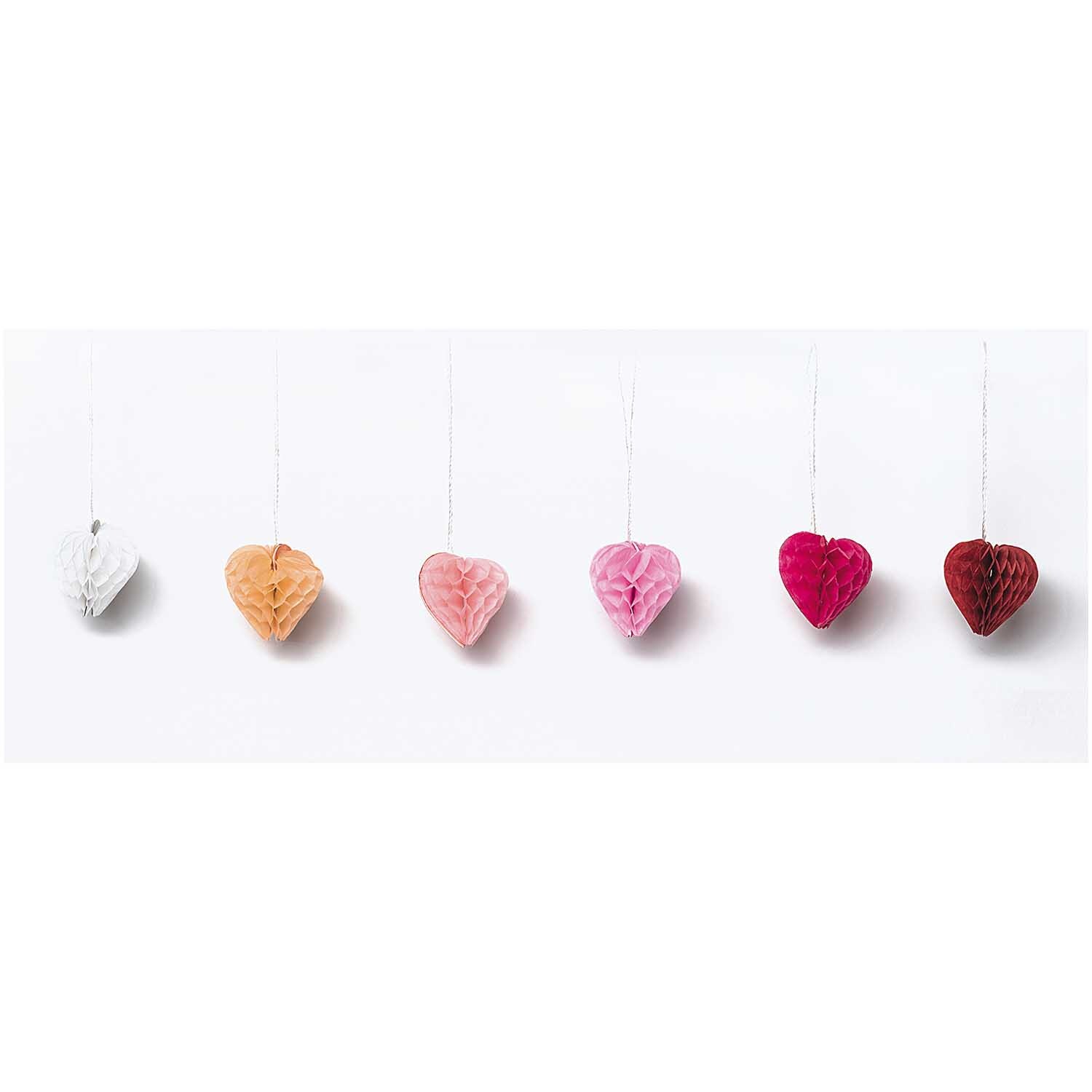 Mini-Wabenbälle Herzen 4cm 6 Stück von Rico Design in verschiedenen Farben, hängend in einer Reihe.