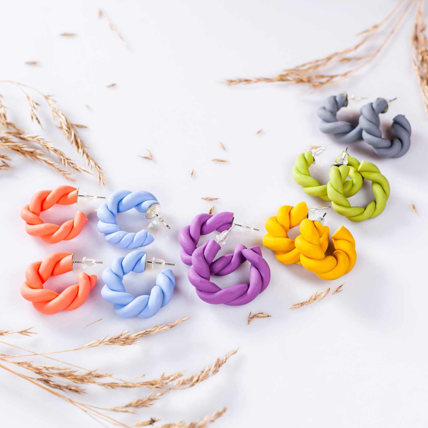 FIMO soft Modelliermasse in verschiedenen Farben, geformt zu dekorativen Ohrringen auf weißem Hintergrund. Ideal für kreative Projekte.