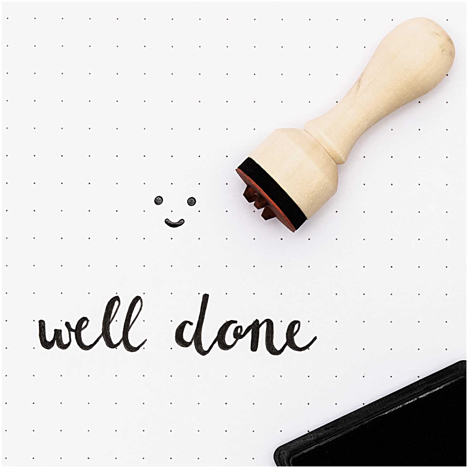 Paper Poetry Mini-Stempel Happy 15mm von Rico Design zeigt einen Holzstempel neben "well done". Ideal für kreative Projekte.