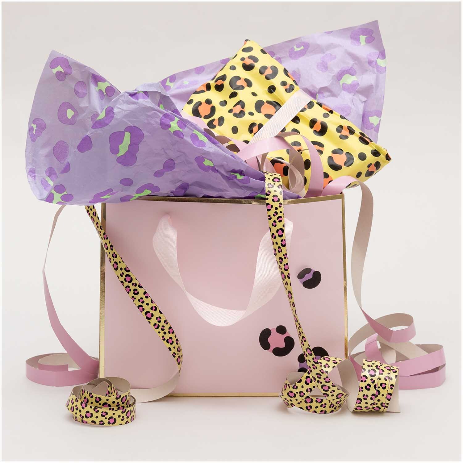 Luftschlangen Acid Leo gold 3,8m von Rico Design in einer rosa Geschenktüte mit Leopardenmuster.