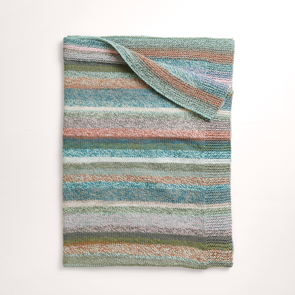 Gestreifte Decke auf grauem Hintergrund – zum Strickset 
