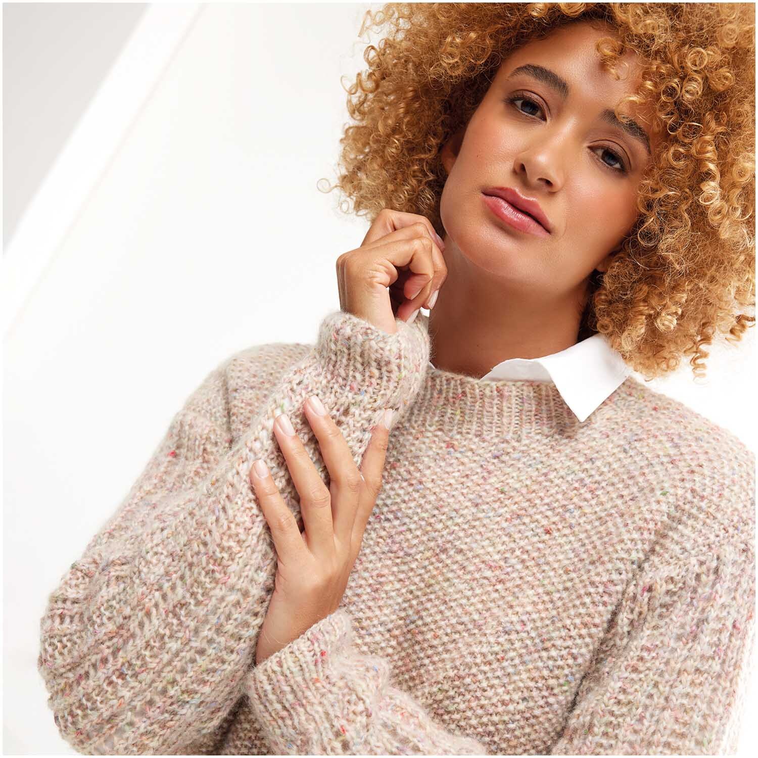 Strickset Pullover Modell 11: Frau trägt einen beigen Strickpullover mit weißem Kragen, lässig und stilvoll.