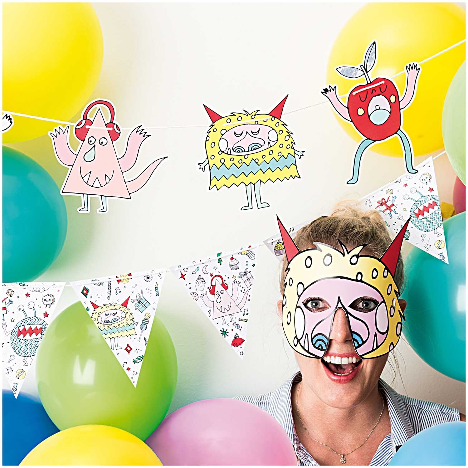 Luftballon Mix mehrfarbig 30cm 12 Stück von Rico Design, umgeben von fröhlichen Partydekorationen und einer lachenden Person mit Maske.