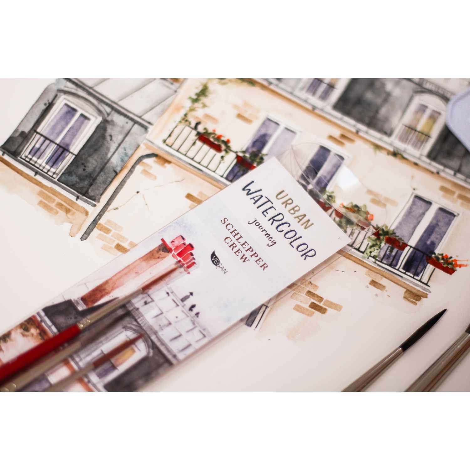 da Vinci Pinsel-Set Urban Watercolor Schlepper Crew vor einem Aquarellbild mit Gebäuden. Ideal für kreative Künstler.