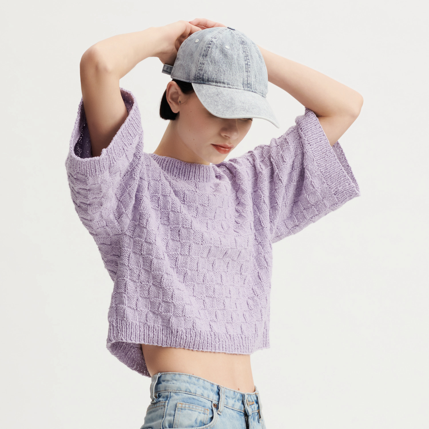 Essentials Super Cotton dk Strickset Shirt Modell 31 in Flieder von Rico Design, getragen von Frau mit Jeans und grauer Kappe.