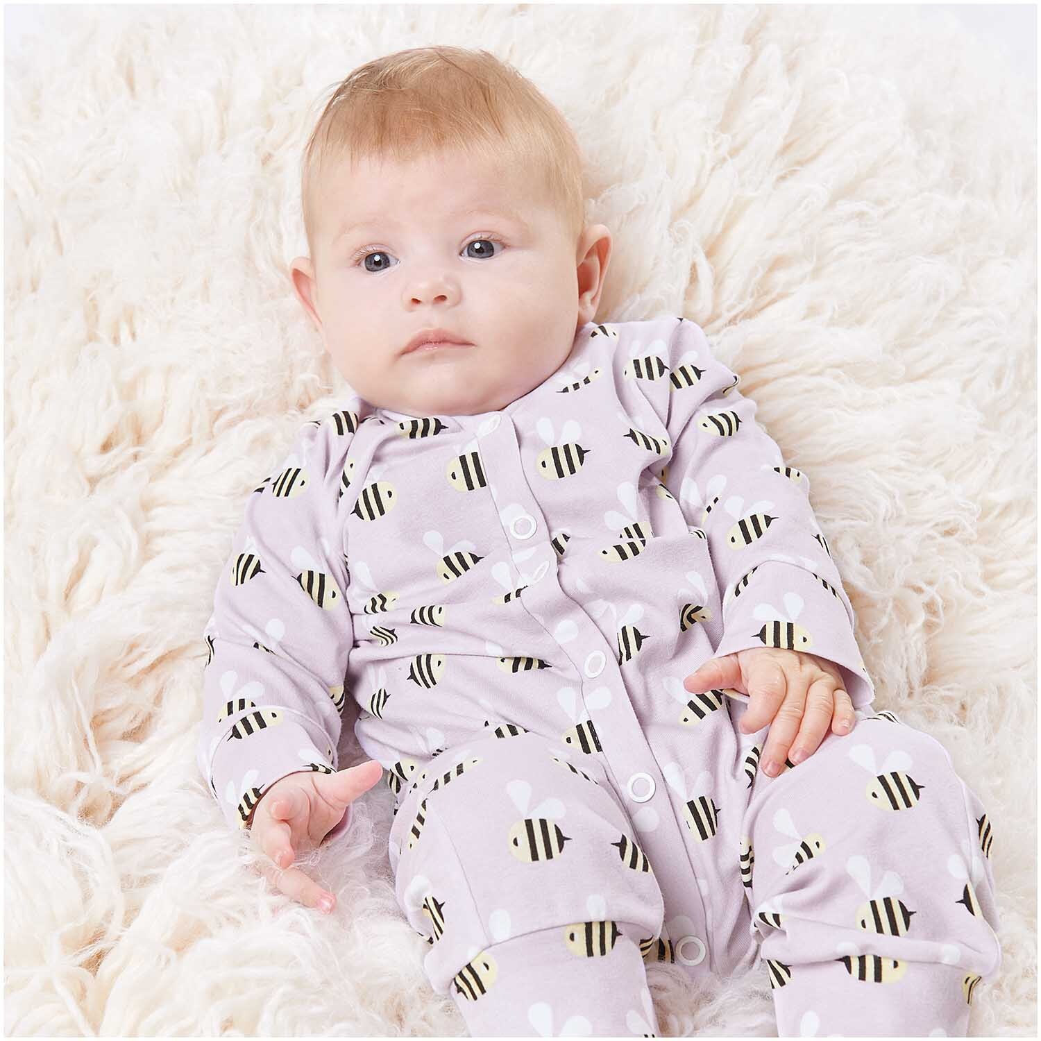 Stoffabschnitt Jersey bedruckt Bienen flieder 80x100cm: Baby in fliederfarbenem Bienen-Strampler von Rico Design auf weichem, cremefarbenem Teppich.