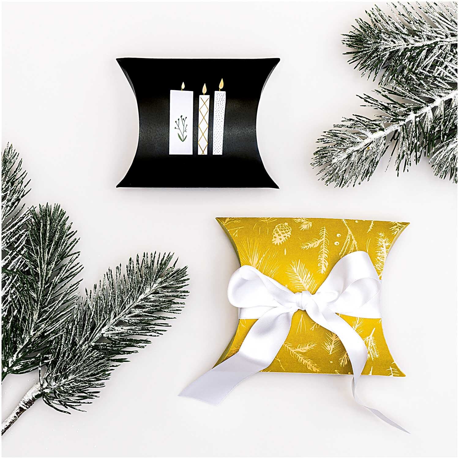 Paper Poetry Geschenkschachteln zeigen festliche Designs mit Kerzenmotiv und Schleife, umgeben von Tannenzweigen. Perfekt für nostalgische Weihnachtsgeschenke.