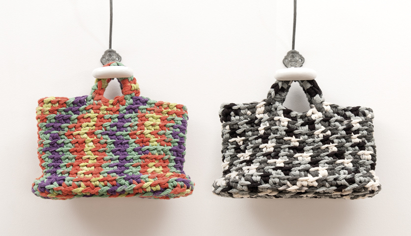 Häkelanleitung Häkeltaschen aus Creative Loopy: Zwei bunte, handgefertigte Taschen, eine in Regenbogenfarben, die andere in Schwarz-Weiß-Muster.