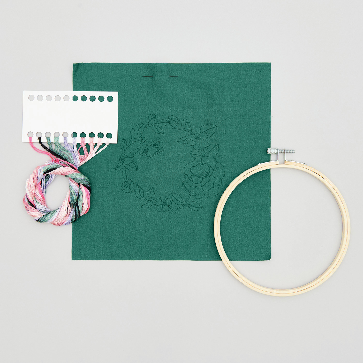 Stickpackung Blumenkranz vorgezeichnet: Grüner Stoff mit Blumenmuster, Stickgarn und Stickrahmen von Rico Design. Ideal für kreative Projekte.