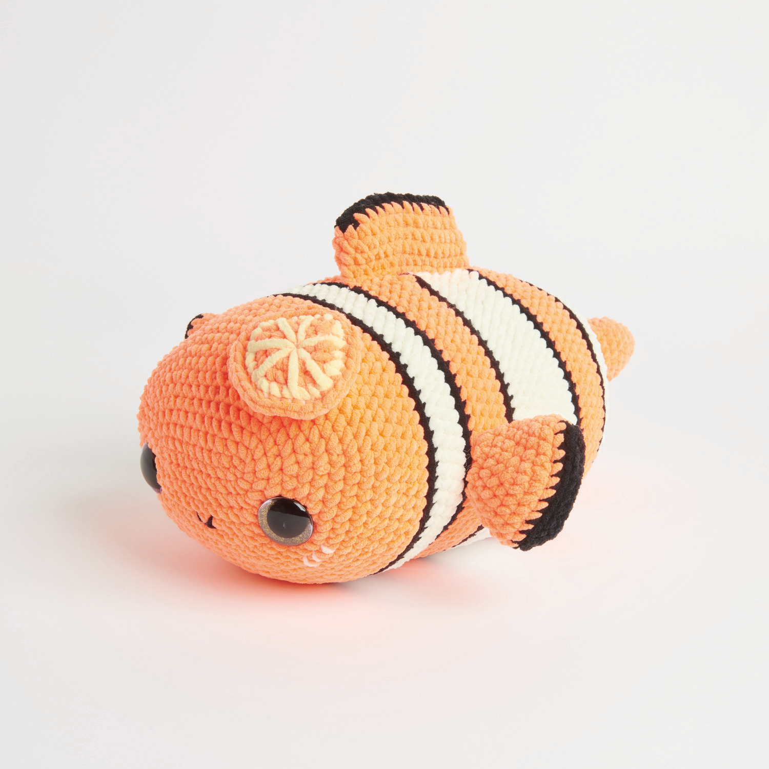 Häkelset Crazy Clown Fish Modell 04: Ein orange-weiß gestreifter, gehäkelter Clownfisch aus Chenillove Big Cuties, ideal für kreative Projekte.