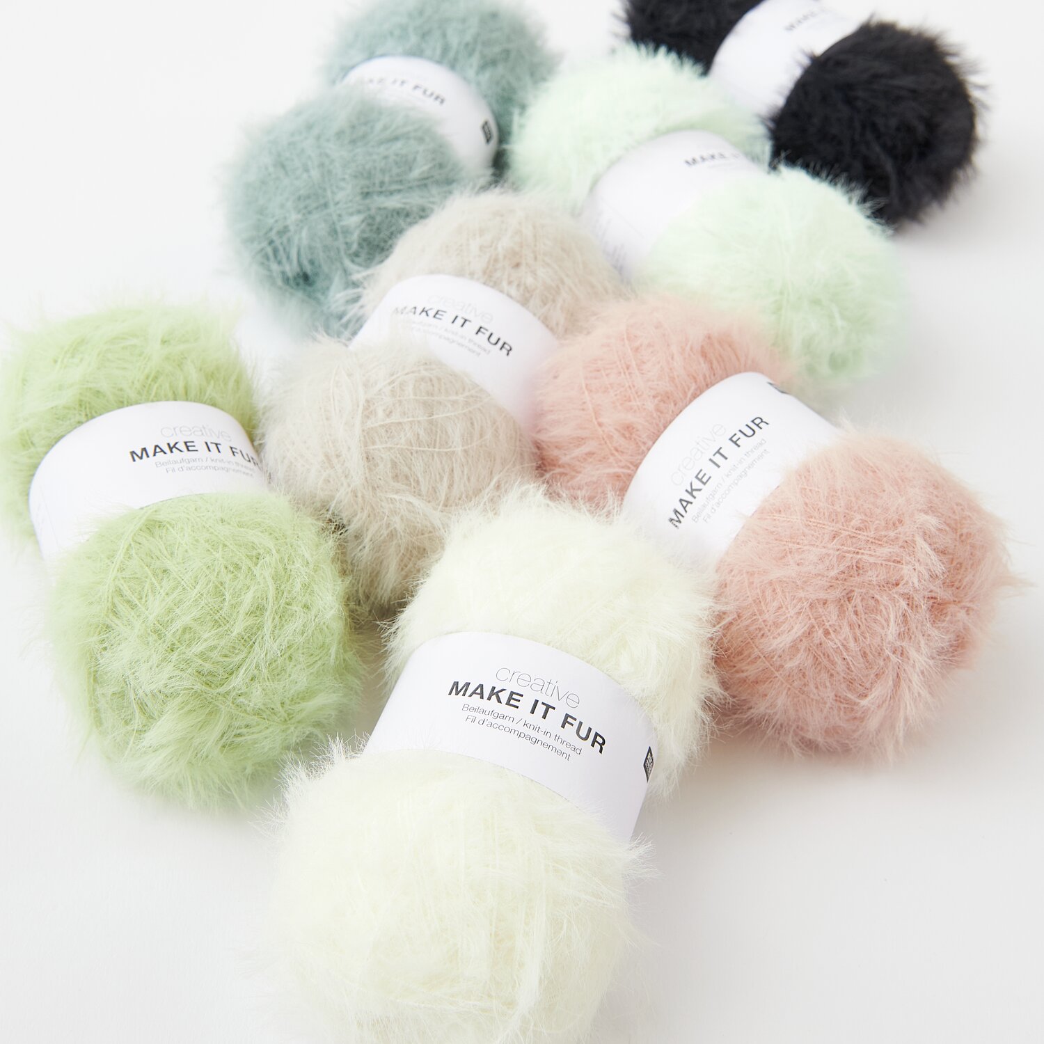 Creative Make It Fur Sortiment zeigt flauschige Wollknäuel in Pastellfarben wie Pistazie und Apricot.