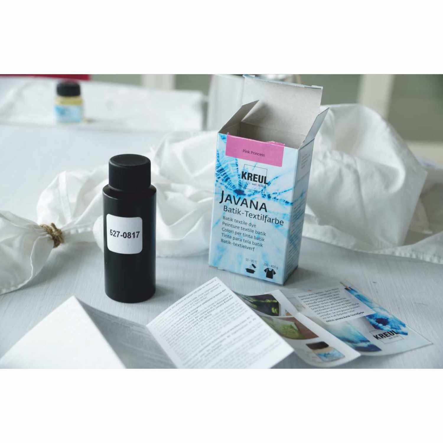 Javana Batik-Textilfarbe von KREUL, 70g, neben geöffneter Verpackung und Anleitungen auf weißem Tisch.